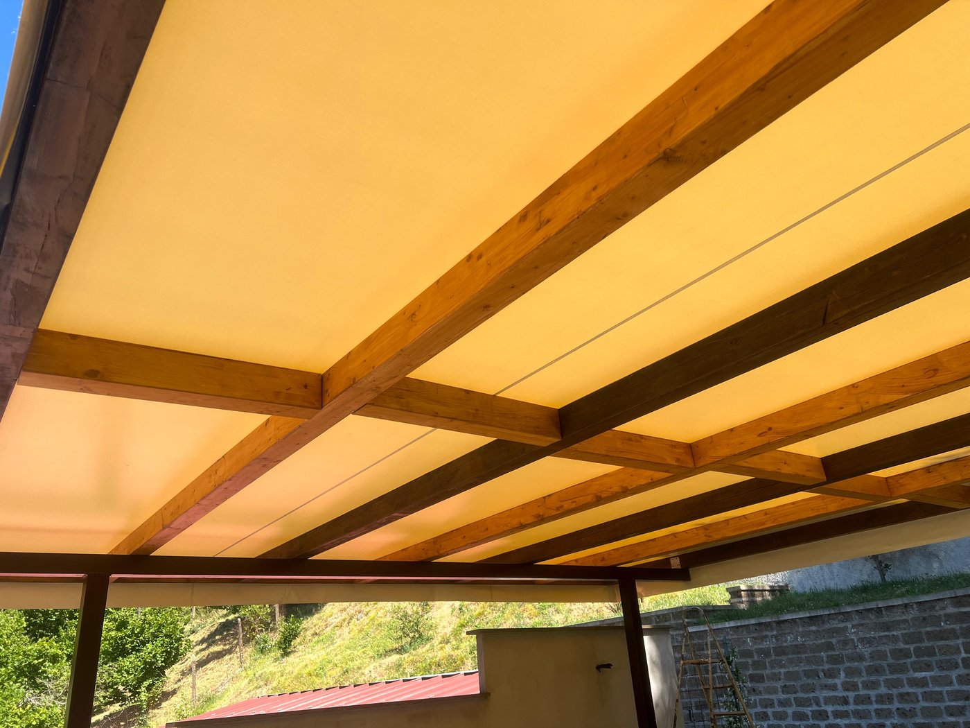Telo di copertura su una pergola con travi in legno