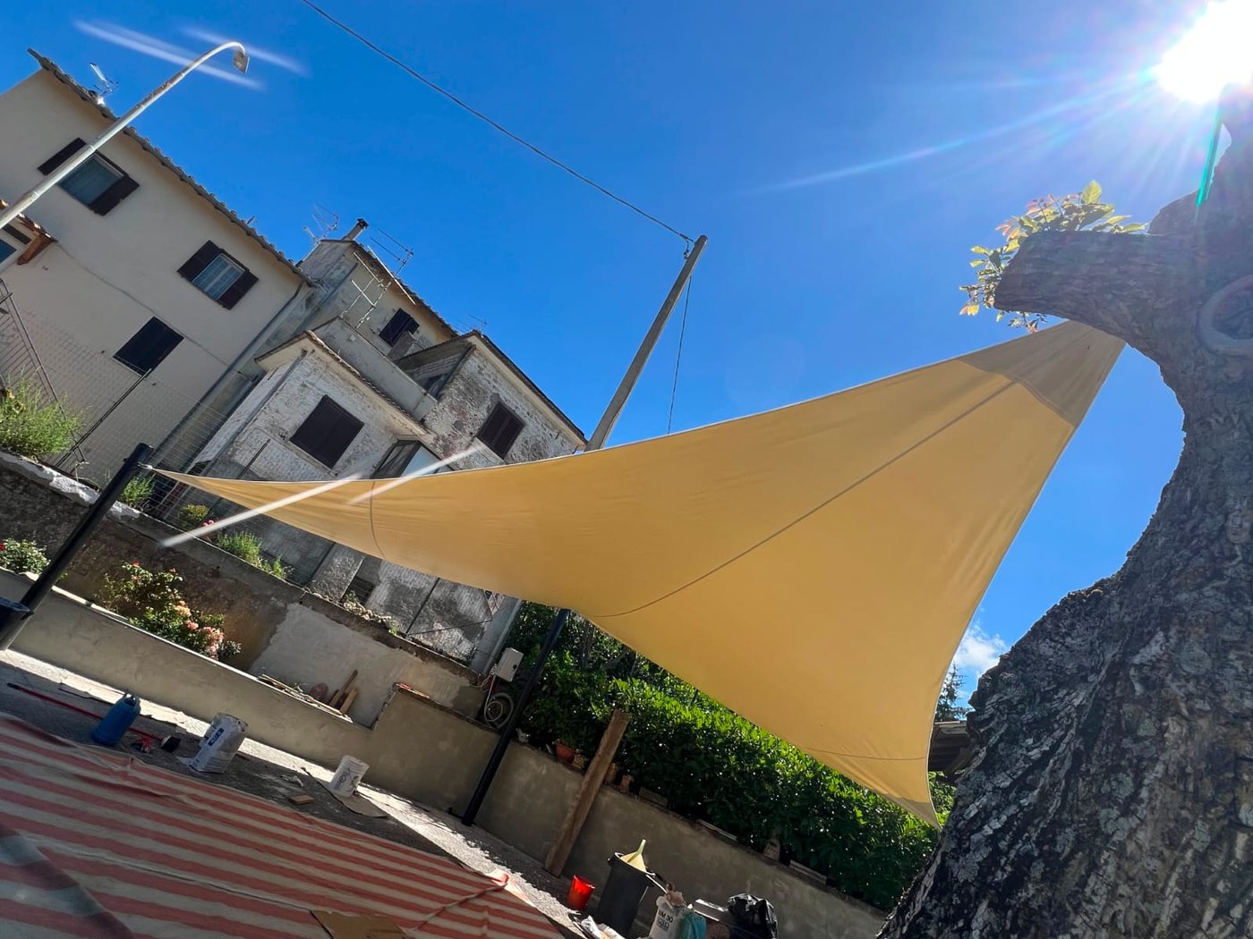 Vela ombreggiante in tessuto tesa sopra uno spazio esterno